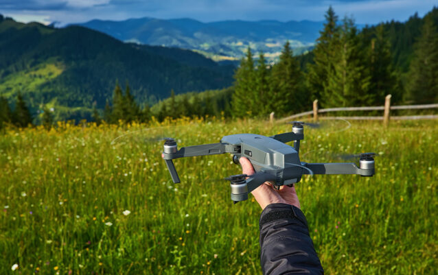 Start the drone, launching from hands. Modern small copter with camera in user hand, against sky. Start the drone, launching from hands. Modern small copter with camera in user hand, against sky. Technological equipment.